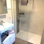 Bad mit Dusche, Waschbecken und Handtüchern.