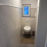 Flur mit Toilette und Fenster mit blauem Glas