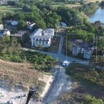 Haus mit Balkonen an ruhiger Straße neben Wald und Wasser