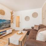 Wohnzimmer mit Sofa, TV und Dekoration an den Wänden.