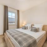 Schlafzimmer mit Bett, Nachttischen und Fenster
