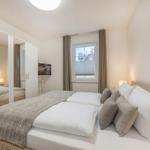 Schlafzimmer mit Bett, Kleiderschrank und Fenster.