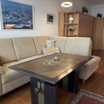 Wohnzimmer mit Sofa, Tisch und Holzmöbeln.
