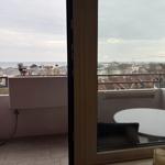 Balkon mit Tisch und Blick auf Meer und Stadt