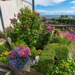 Terrasse mit Blumenbeeten und Meerblick