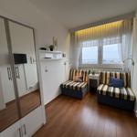Zimmer mit zwei Sitzbänken, Fenster mit Meerblick und Spiegelschrank.