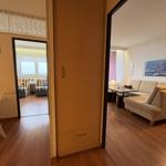 Wohnung mit Essbereich, Schlafzimmer und Wohnzimmer mit Sofa und Tisch.