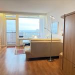 Wohnzimmer mit Sofa, Holzboden und Meerblick über Balkon