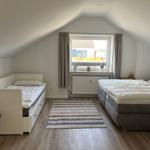 Schlafzimmer mit Doppelbett, Einzelbett und Fenster mit Blick.