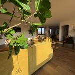 Wohnzimmer mit gelben Sitzmöbeln, Holzboden und Fußballtisch.