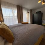 Schlafzimmer mit Bett, Fenster und Kleiderschrank.