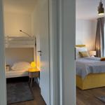 Zwei Schlafzimmer mit Bett, Nachttisch und Lampen.