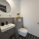 Badezimmer mit Waschbecken, Toilette und Spiegel