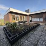 Moderne Villa mit Terrasse und Gartenbereich. Blick in Wohnbereich mit Sitzgruppe.