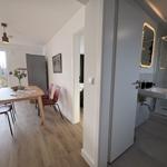 Essbereich mit Tisch und Stühlen, angrenzender Badezimmer mit Dusche und Waschbecken.