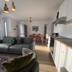 Wohnung mit Küche, Essbereich und Wohnzimmer mit Sofa und Stühlen.