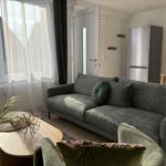 Wohnzimmer mit Sofa, Couchtisch und Küchenbereich im Hintergrund.