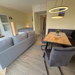 Wohn- und Essbereich mit Sofa, Esstisch und moderner Beleuchtung.