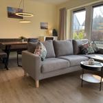 Wohnzimmer mit Sofa, Esstisch und Fensterblick