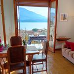 Esszimmer mit Blick auf See und Berge. Wohnbereich mit Sofa und Stehlampe.