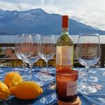 Tisch mit Wein, Gläsern und Zitronen auf Balkon mit Bergblick