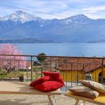 Terrasse mit Liegen und Blick auf See und Berge.