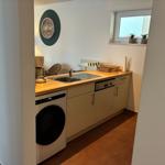 Küche mit Spüle, Waschmaschine und Waschbecken