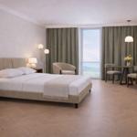 Ein Schlafzimmer mit Bett, Schreibtisch und Fenster mit Blick.