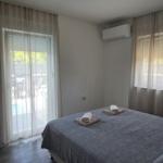 Schlafzimmer mit Bett, Klimaanlage und Blick auf Poolbereich.