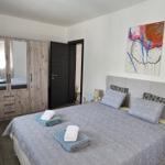 Schlafzimmer mit Bett, Kleiderschrank und Wandbild.