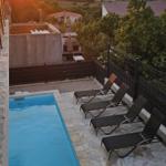 Poolbereich mit Liegestühlen und Blick auf Sonnenuntergang