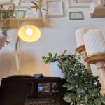 Lampe, Radio und Pflanzen auf einem Tisch zwischen zwei Sesseln