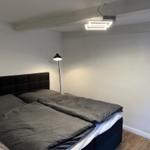 Bedroom with double bed, black headboard, and floor lamp.