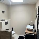 Bathroom with shower, sink, and towel heater.