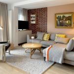 Wohnzimmer mit Sofa, Couchtisch und Fernseher an Backsteinwand.