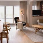 Wohn- und Essbereich mit Holzboden, Sofa, Sessel und Esszimmertisch.