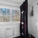 Bathroom with shower, window, and dark curtain with star pattern.