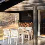 Patio with table and chairs, woodpile, and view into the house.