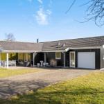 A house with garage, terrace and garden under blue sky.