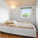 Bedroom with bed, window, and wooden ceiling.