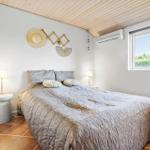 Bedroom with bed, window, and wooden ceiling.