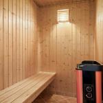 Sauna with wooden walls, bench, and heater.