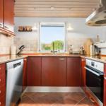 Kitchen with wooden cabinets, sink and window view
