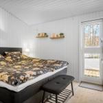 Bedroom with bed, window and wooden floor.