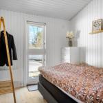 Bedroom with bed, coat stand, and window to balcony.