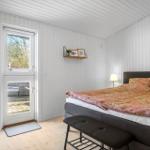 Bedroom with bed, door to balcony, and wall shelf.
