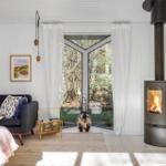 Living room with fireplace, sofa, and garden view through window.
