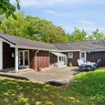 Cottage with terrace, garden and seating. Wooden walls and roof tiles.