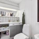 Badezimmer mit Waschbecken, Spiegel, Toilette und Fenster