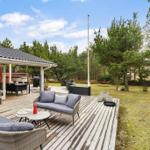 Terrasse mit Sitzgelegenheiten, Grill und Hängematten im Grünen.